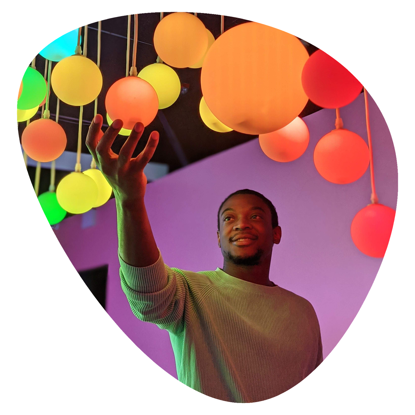 Clifton holding a glowing ball among colorful hanging lights
